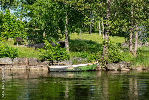 Rowing boat tied up at a stone pier in summer sunlight