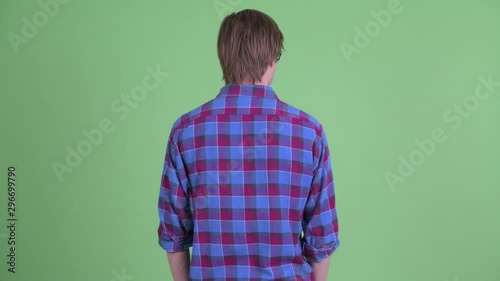 Rear view of young hipster man thinking while looking around