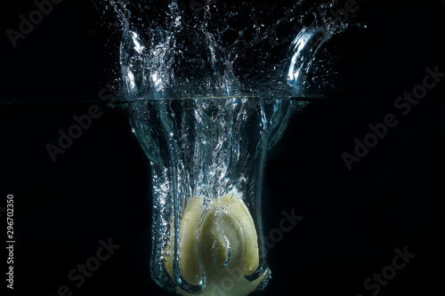 Water splash and fruits isolated on black backgroud. Fresh Lemon and Pear.