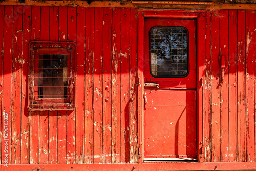 Old decaying train carriage with peeling red paint