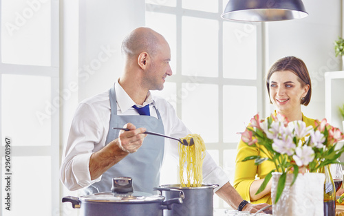 Smiling young couple cooking food in the kitchen