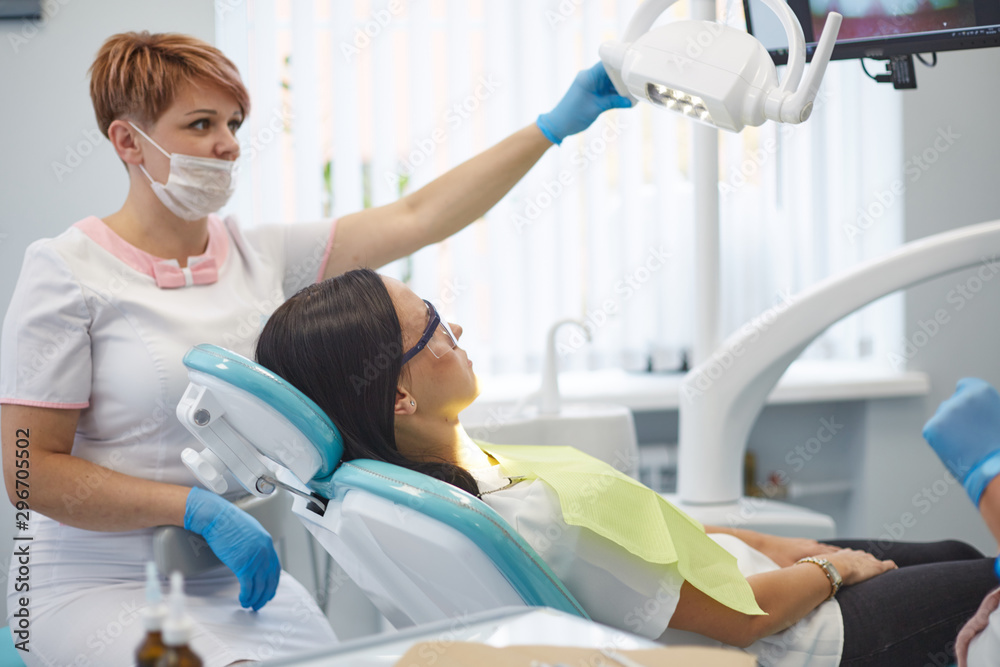 Doctor dentist treats teeth of a beautiful young girl patient. The girl on reception at the dentist. Doctor dentist treats tooth Doctor dentist treats teeth of a beautiful young girl patient. The girl on reception at the dentist. Doctor dentist treats tooth