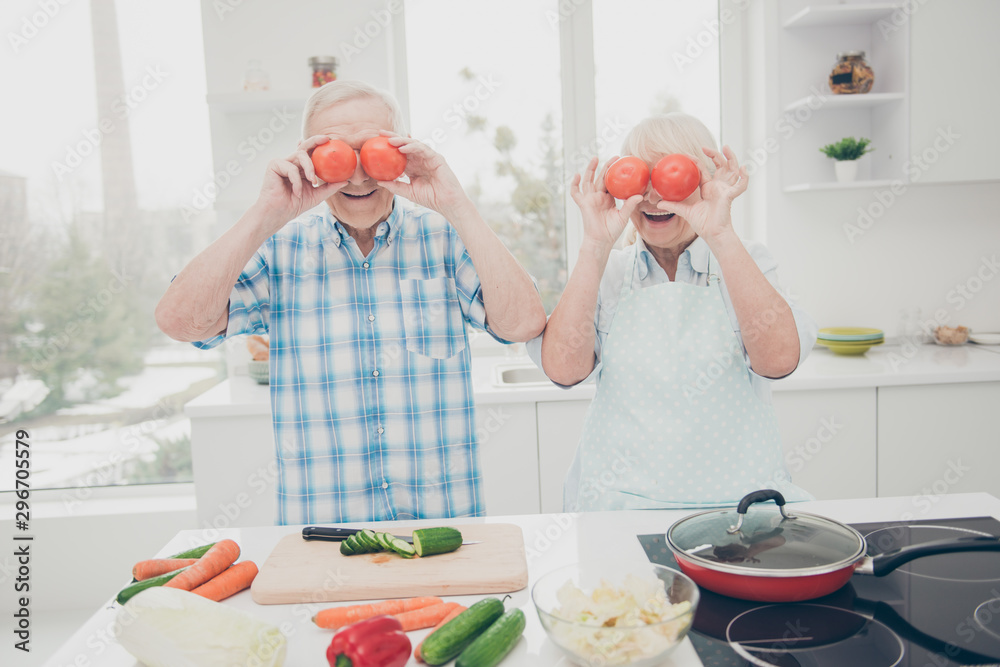 Portrait of nice retired people grandmother grandfather hold hand tomato laugh feel rejoice stand light room indoors Portrait of nice retired people grandmother grandfather hold hand tomato laugh feel rejoice stand light room indoors