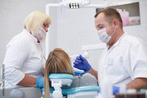 Doctor dentist treats teeth of a beautiful young girl patient. The girl on reception at the dentist. Doctor dentist treats tooth