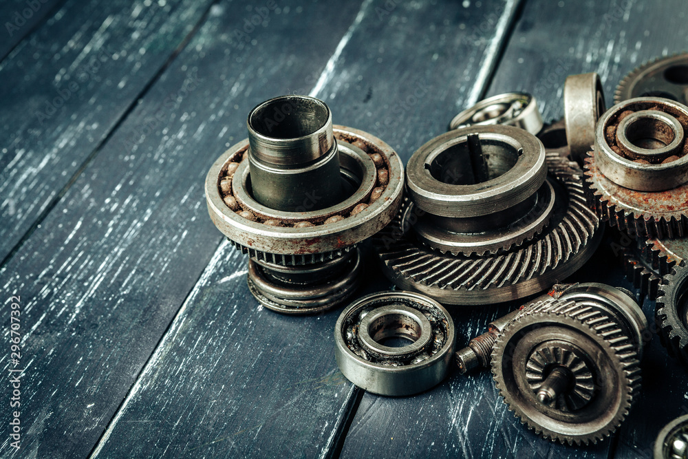 Car parts gears and bearings on wooden background Car parts gears and bearings on wooden background