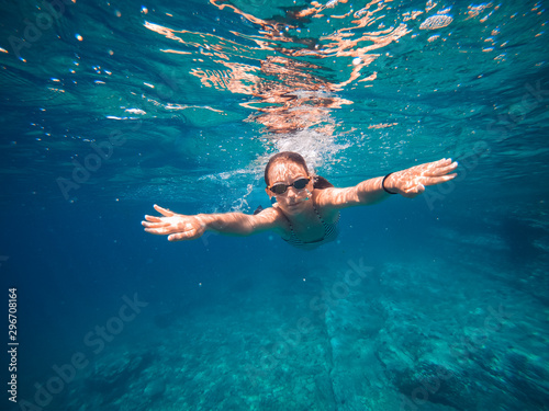 Girl swimming in the shallow sea water