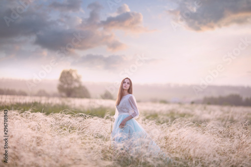 girl walk in the field against the sunset, the bride against the sunset