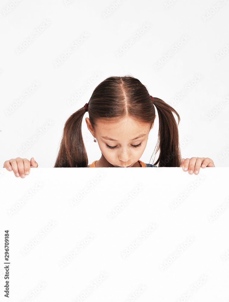 Little thinking girl holds white banner with copy space. Little thinking girl holds white banner with copy space.