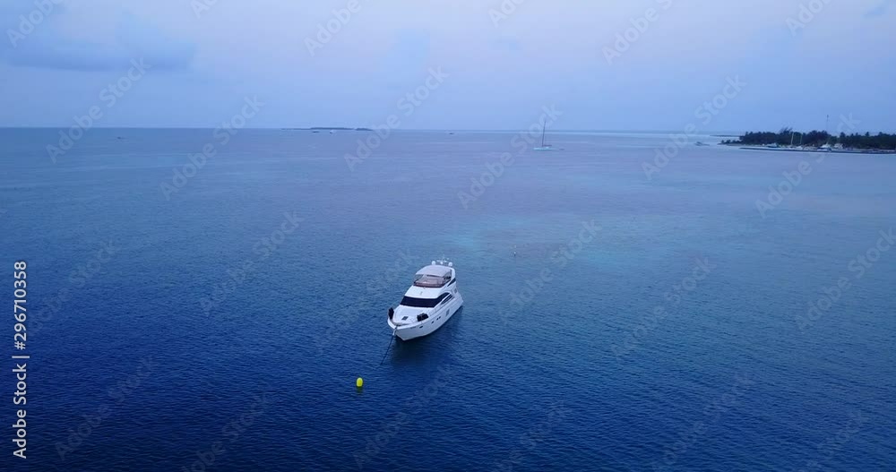 aerial drone parallax shot above the boat moored in blue Caribbean sea. Wide shot with copy space