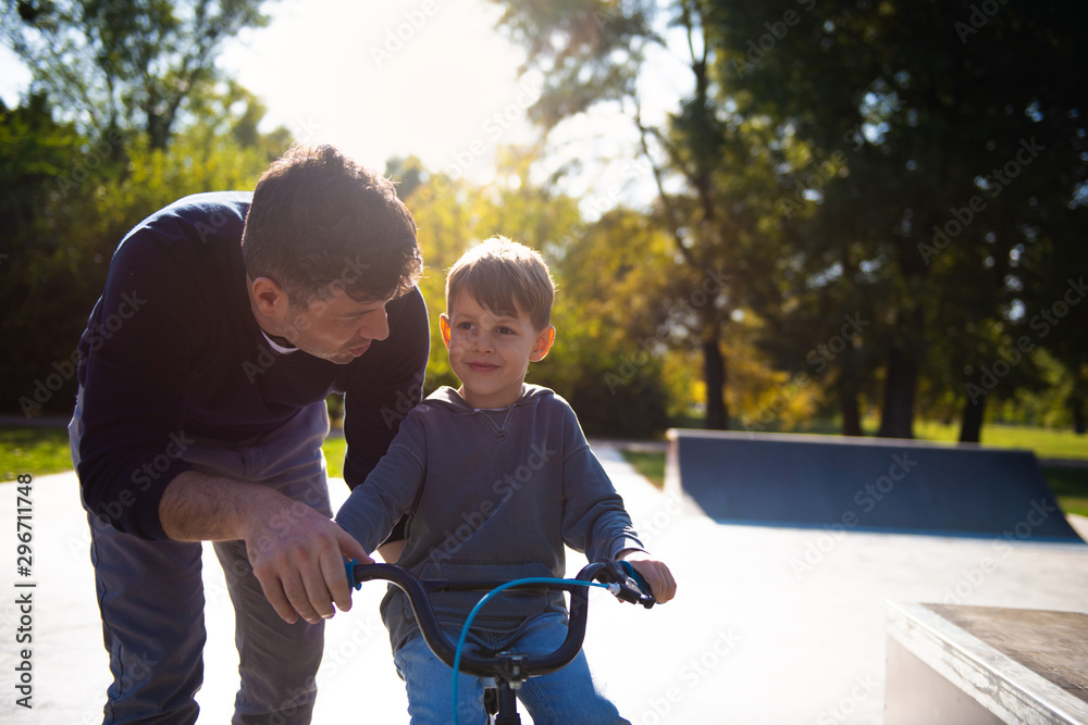 Fototapeta premium Father Learning his son to ride a bicycle