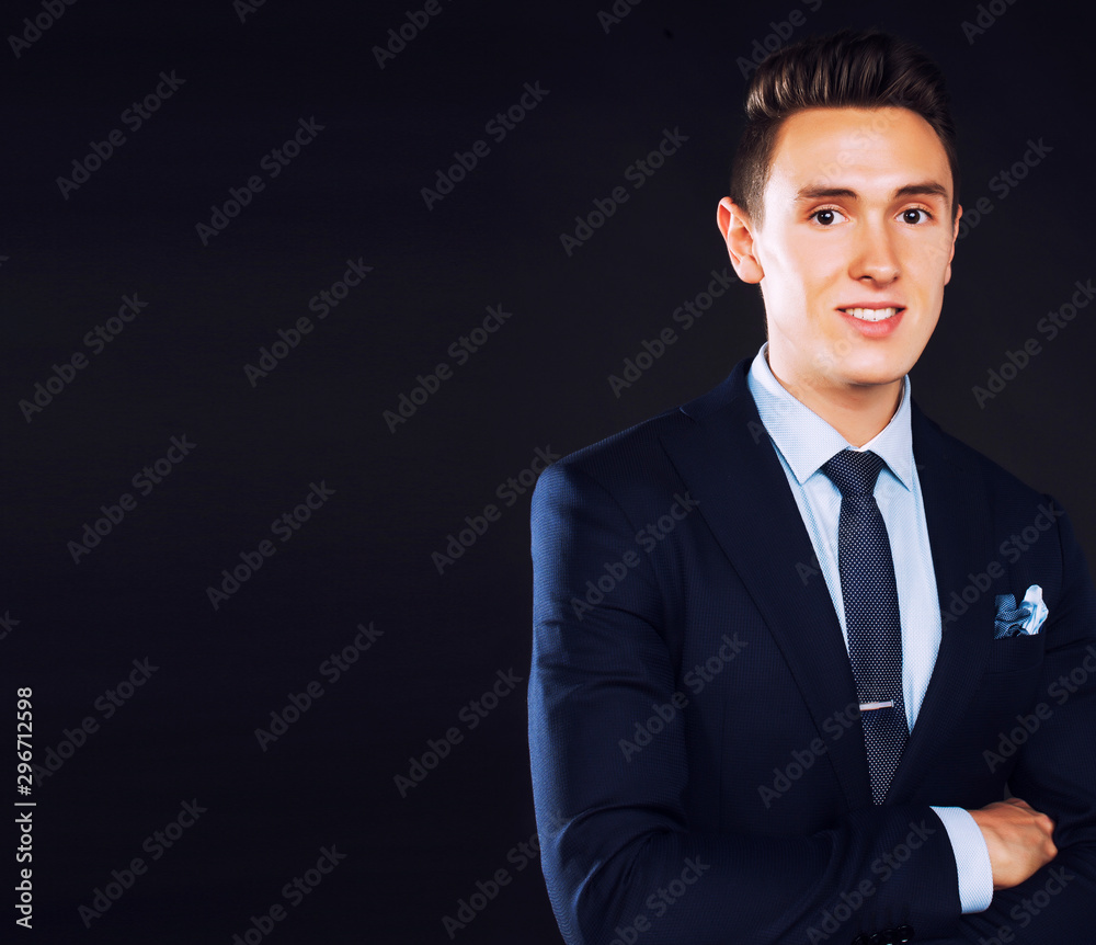young pretty business man standing on black background, modern hairstyle, talking on phone emotional young pretty business man standing on black background, modern hairstyle, talking on phone emotional