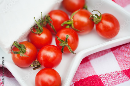 brie cheese and cherry tomatoes on red tablecloth. close up © Artsaba Family