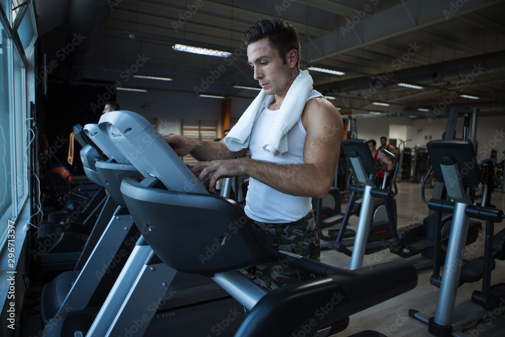 Muscular man using exercise machine in gym Muscular man using exercise machine in gym