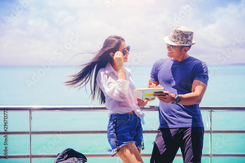 Young couple with a map talking and looking for destination on holiday while travel on cruise ship © Panumas