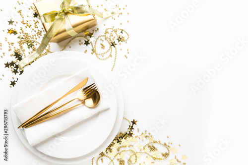 Christmas table setting with dishware, golden silverware on white background. Top view. Xmas