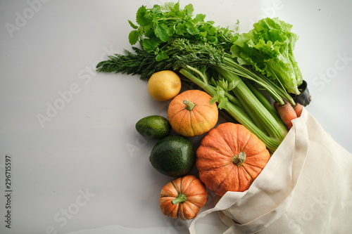 Fresh colorful organic vegetables coming out from eco shopping bag - captured from above (top view, flat lay).