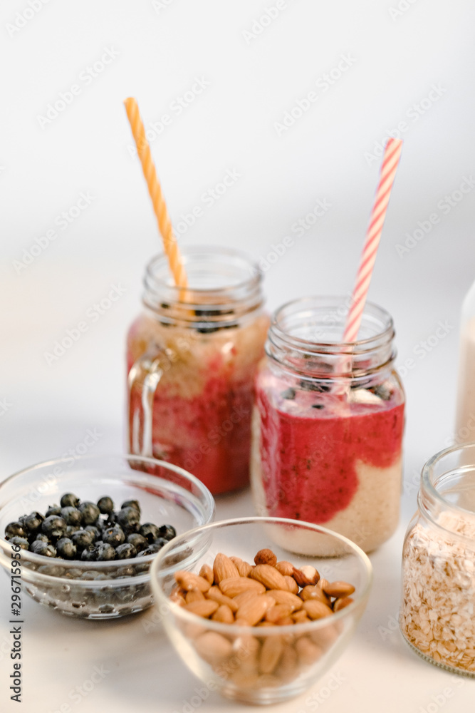 Freshly blended fruit smoothies of various colors and tastes in glass jars. Healthy breakfast - milk in a glass jar, oatmeal, almonds and blackberries Freshly blended fruit smoothies of various colors and tastes in glass jars. Healthy breakfast - milk in a glass jar, oatmeal, almonds and blackberries
