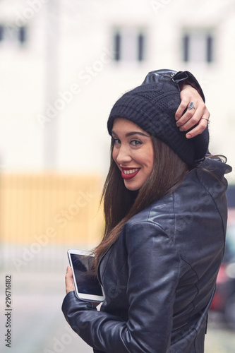 Young woman with hat and cellphone on the street. © astrosystem
