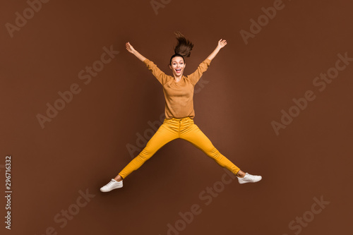 Full length body size photo of cheerful positive cute nice sweet pretty girl expressing overjoying emotions jumping in star shape isolated over brown pastel color background