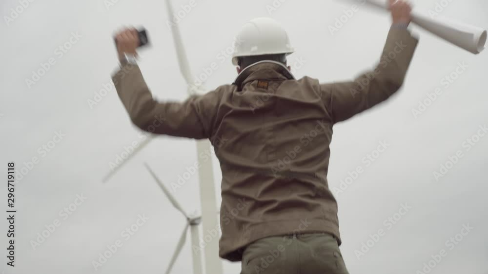 Engineer talking on phone in background of wind farm, dancing, singing and shouting. Engineer talking on phone in background of wind farm, dancing, singing and shouting.