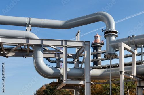 Petrochemical distribution pipe . Overhead steel piping blue sky and the lighthouse background.
