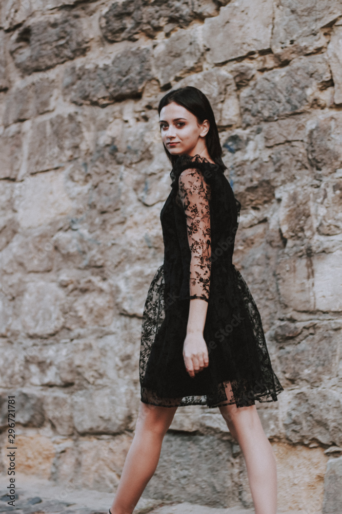 Black-haired girl. Black lace dress. Model shooting. Fashion and style.