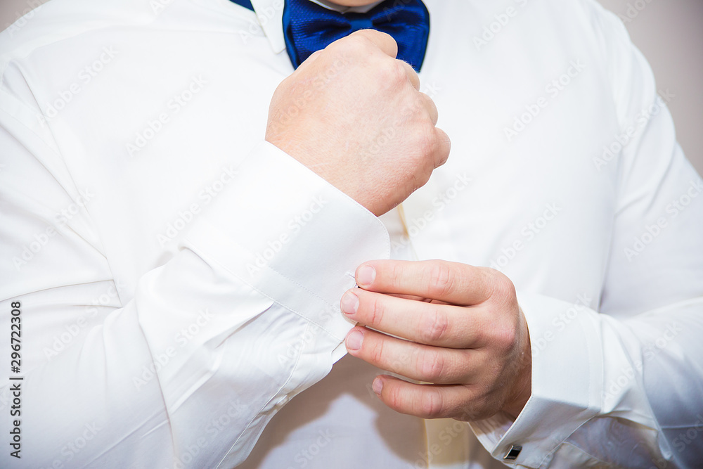 Groom buttons cuffs on his shirt
