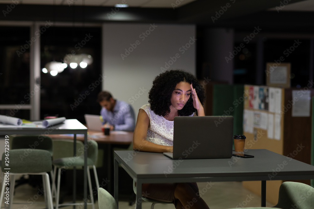 Two young creative professionals working late in a modern office 