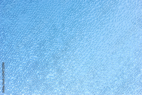 Water droplets on the glass with a blue background.