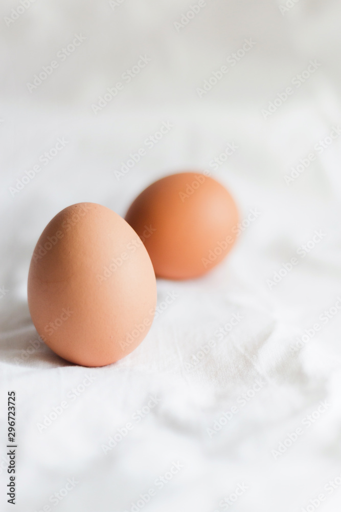 Brown chicken eggs on a light background of cotton fabric, Studio photo, light from the window, selective focus. Brown chicken eggs on a light background of cotton fabric, Studio photo, light from the window, selective focus.