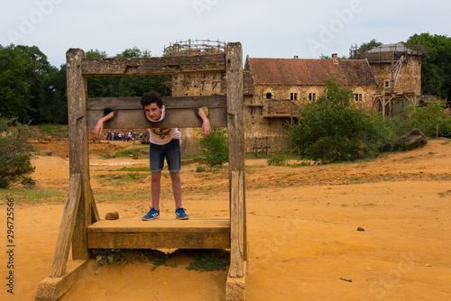 Un enfant dans un carcan. Un garçon au pilori. Torture au Moyen-âge. Un condamné exposé. Justice médiévale. photo