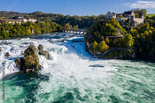 Rhine Falls (Rheinfall), Switzerland panoramic aerial view. Tourist boat in waterfall. Bridge and border between the cantons Schaffhausen and Zürich. Cliff-top Schloss Laufen castle, Laufen-Uhwiesen