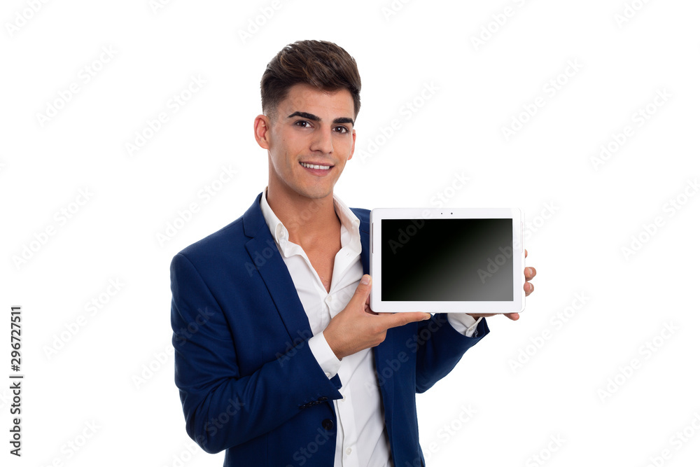 young smiling businessman showing a white tablet mobile. He is wearing a blue jacket suit and a white shirt. He is in a photo studio. young smiling businessman showing a white tablet mobile. He is wearing a blue jacket suit and a white shirt. He is in a photo studio.