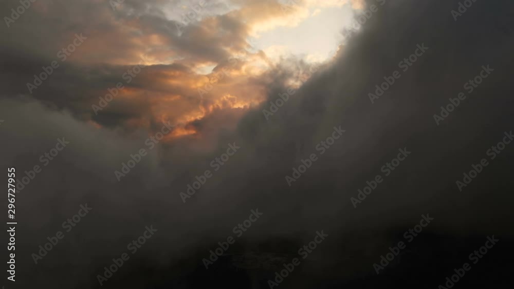 Aerial view flying through cumulus thunderclouds at sunset. Gold colored sunset cloudiness in high contrast. Real sky. The concept of dreams and weather forecast