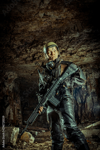 Beautiful woman soldier in leather clothing with the gun