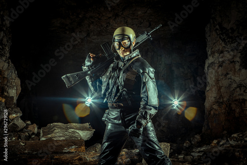 Beautiful woman soldier in leather clothing with the gun