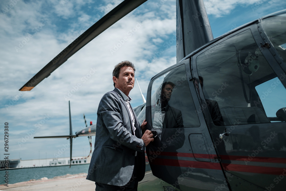 Businessman entering his private helicopter Businessman entering his private helicopter