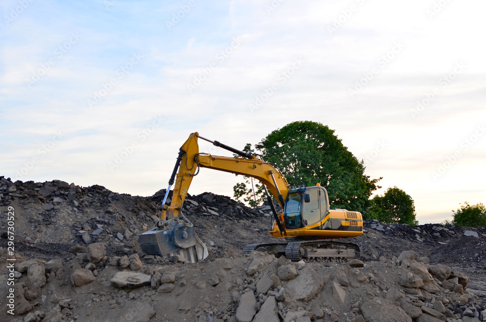Excavator with crusher bucket for crushing concrete. Construction waste recycling for construction mix. Sifting and grinding bucket for the separation of concrete into fractions of higher quality.