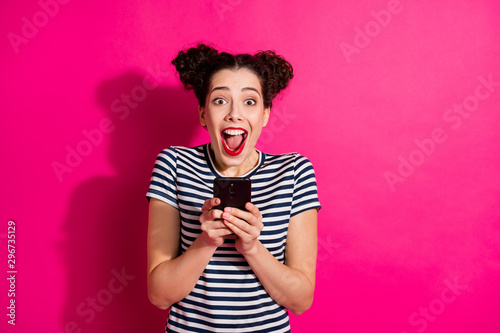 Photo of cheerful cute trendy nice charming fascinating attractive youngster screaming while watching video on phone wearing striped t-shirt isolated over fuchsia vivid color background © deagreez