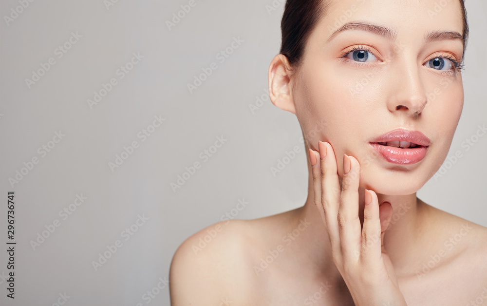 Beautiful young woman with clean fresh skin touch her own face with her right hand looking straight. Cosmetology, beauty and spa. Beautiful young woman with clean fresh skin touch her own face with her right hand looking straight. Cosmetology, beauty and spa.