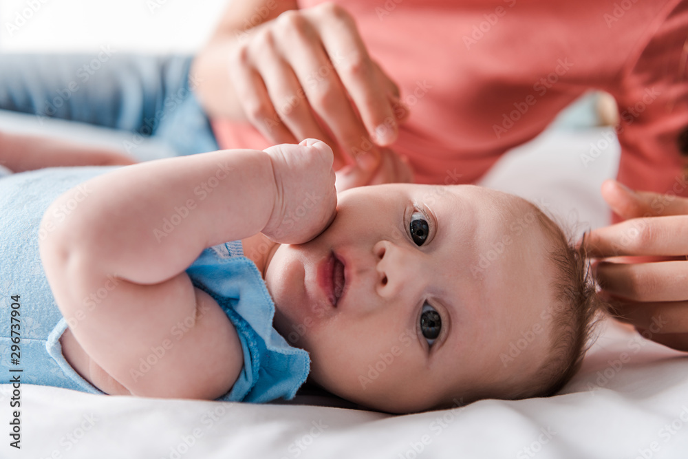 selective focus of surprised infant baby near mother selective focus of surprised infant baby near mother