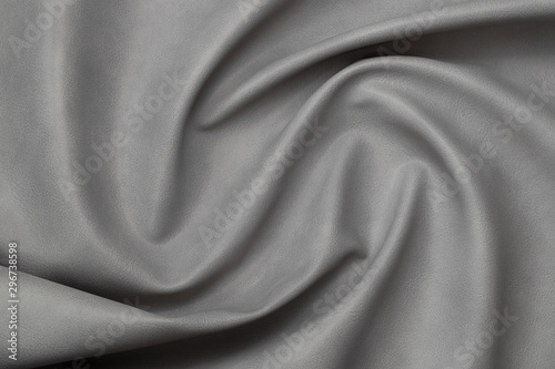 gray artificial leather with waves and folds on PVC base 