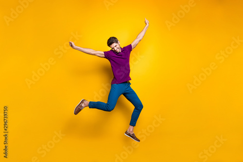 Full length body size photo of cheerful positive attrative man in blue pants trousers leather shoes flying jumping running up to his dream isolated over vivid color background