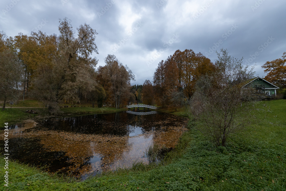 White bridge across the pond in the Park. Mikhailovskoye in October. Estate of Pushkin's parents in Mikhailovskoye village, Pskov region, Russia