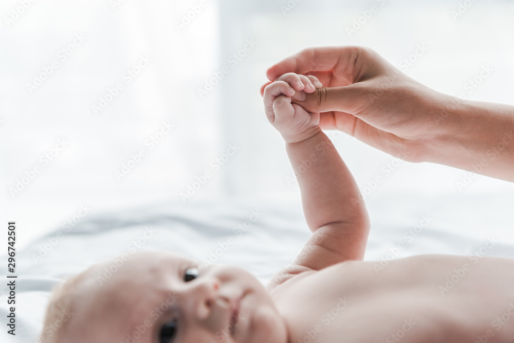 selective focus of woman touching hand of infant baby selective focus of woman touching hand of infant baby