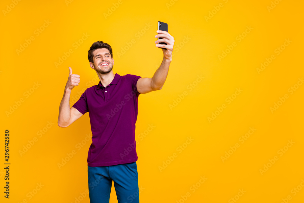Portrait of his he nice attractive cheerful cheery brunette guy taking making selfie showing thumbup isolated on bright vivid shine vibrant yellow color background Portrait of his he nice attractive cheerful cheery brunette guy taking making selfie showing thumbup isolated on bright vivid shine vibrant yellow color background