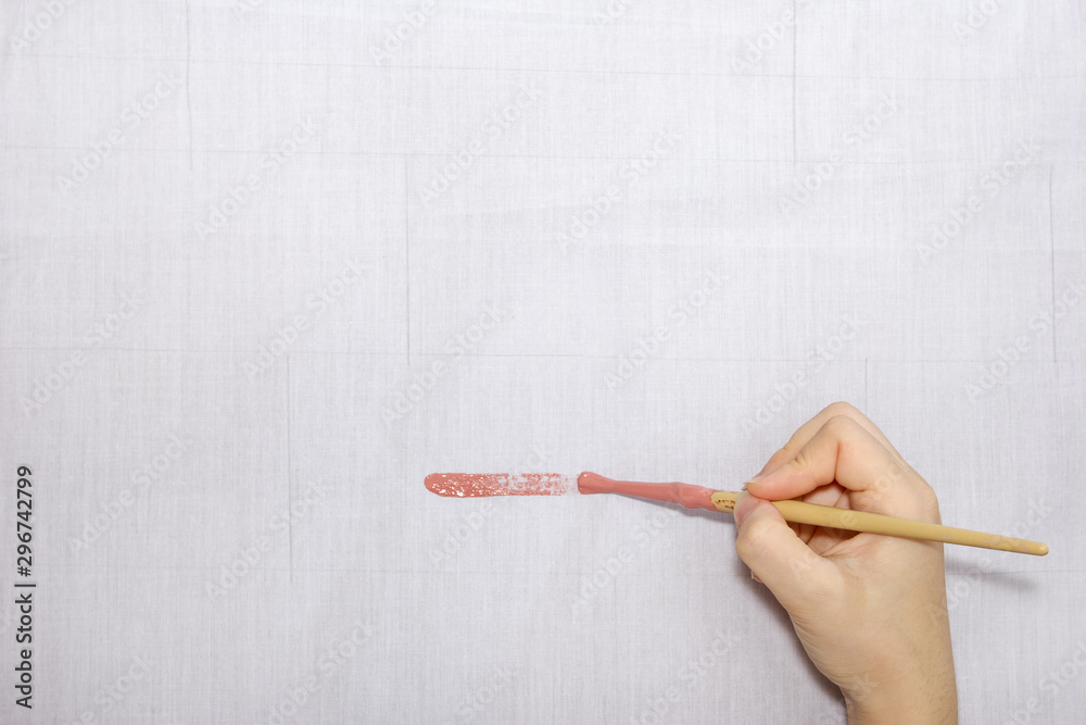 hand holding paintbrush paint on gray cloth hand holding paintbrush paint on gray cloth