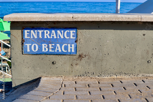Entrance to the beach sign on a wall