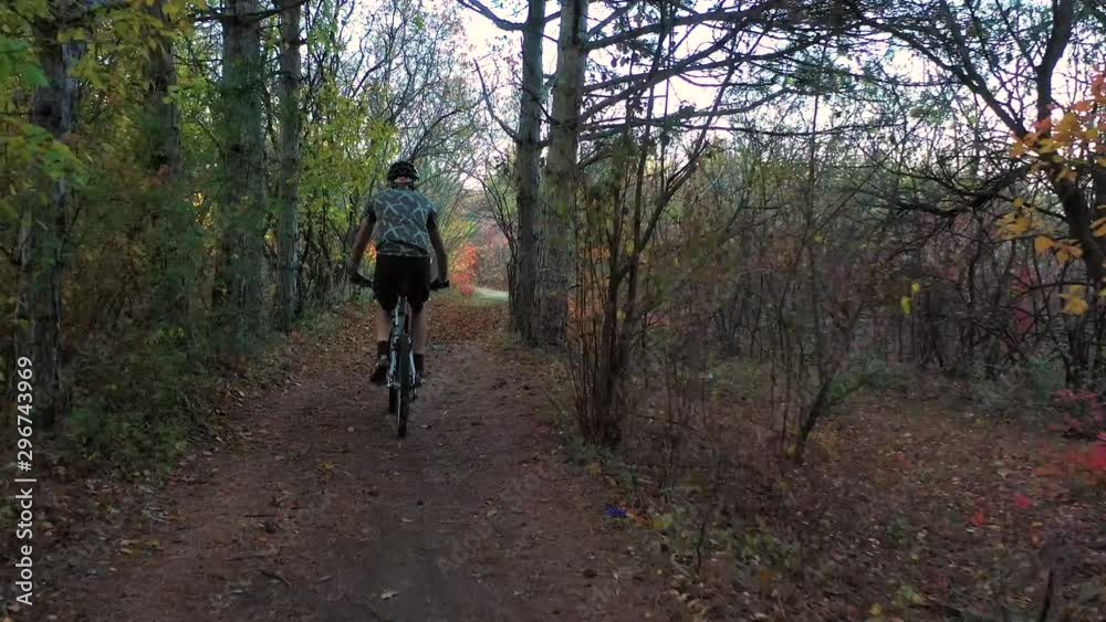 man riding bicycle in beautiful autumn forest man riding bicycle in beautiful autumn forest