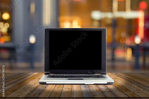 laptops on desk with blur restaurant background,top wooden table